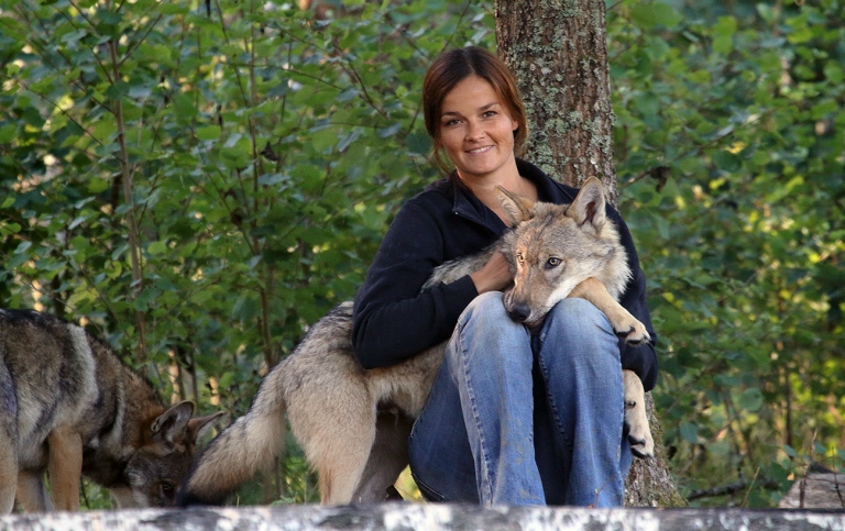 The researcher Christina Hansen Wheat with a young wolf on her lap