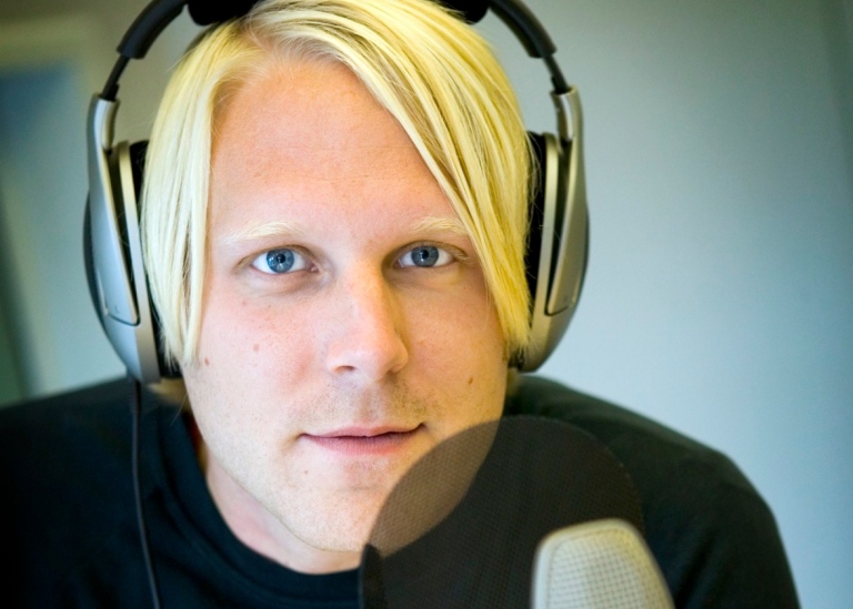 Tobias Svanelid sitter vid en mikrofon.