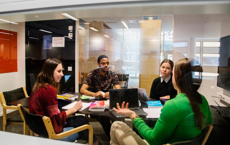 Studenter pluggar tillsammans i ett av grupprummen på Stockholms universitetsbibliotek.