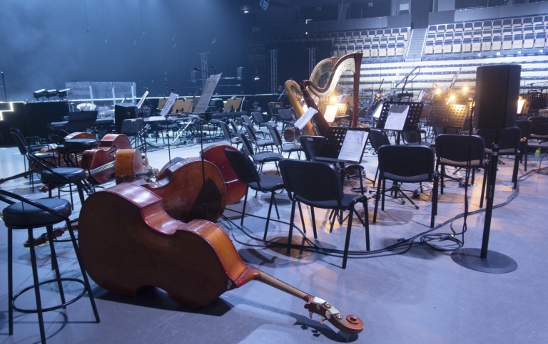 Tom scen med liggande klassiska instrument framför en tom konsertsal.