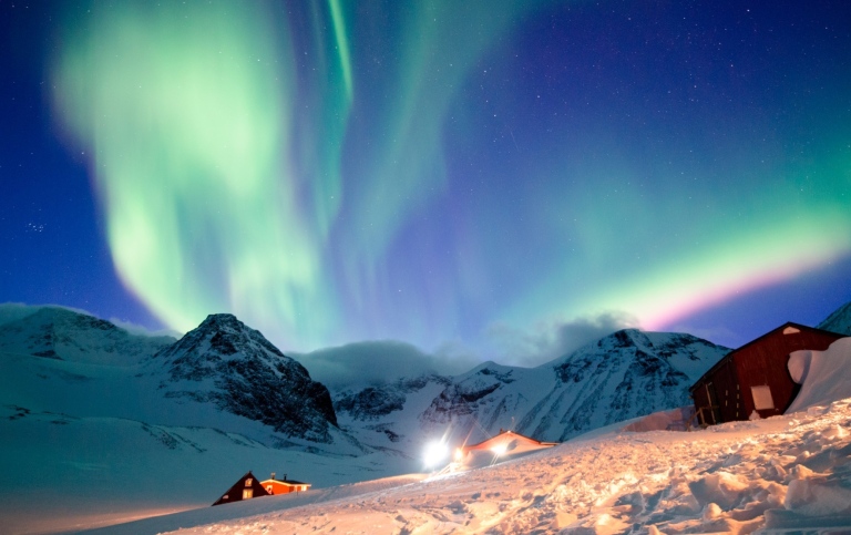 Northern lights above snowy mountains