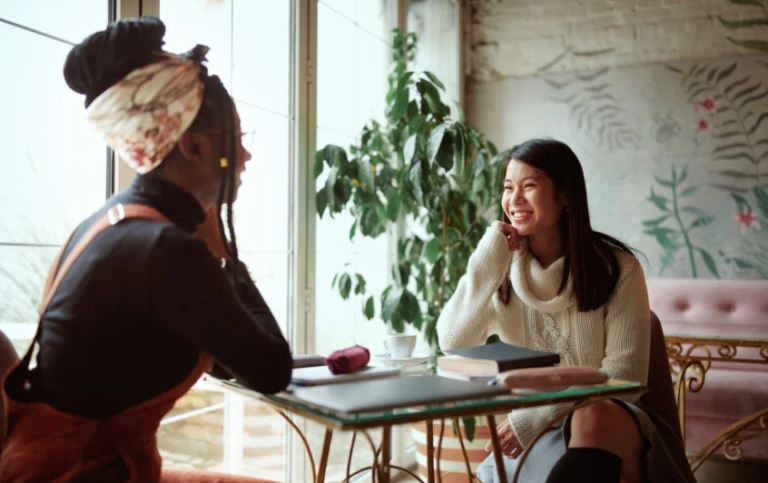 Two persons sitting talking at a table. Photo: GettyImages