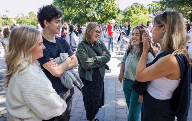 Nya student samtala ute i grupp på välkomstagen.