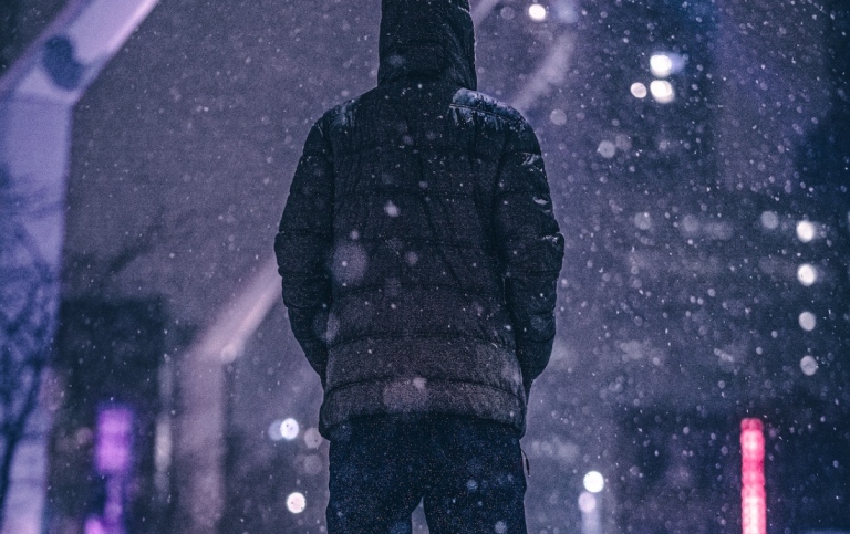 Man i täckjacka i snöfall. Foto: Kevin Mach från Pexels.
