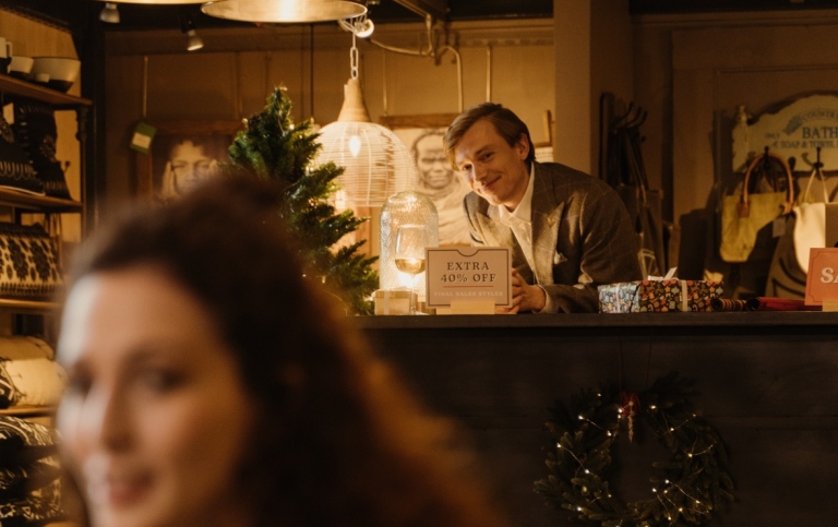 En kvinna i förgrunden och en man bakom en bardisk på lokal 
