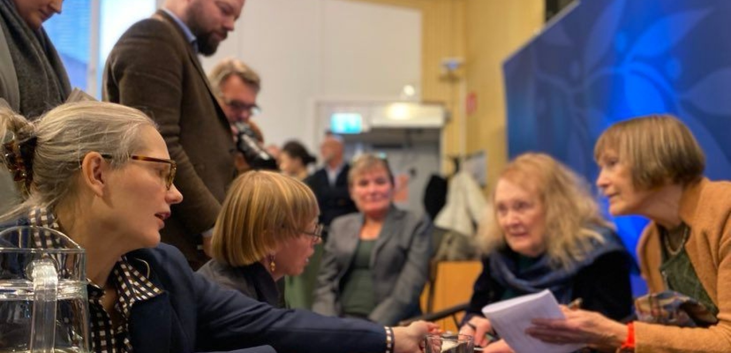 Annie Ernaux signerar böcker i en ring av besökare