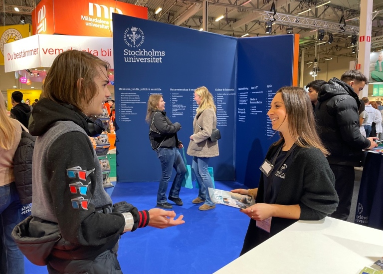 En studentambassadör pratar med en besökare på Saco Studentmässa.