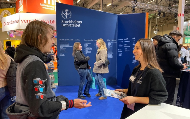 En studentambassadör pratar med en besökare på Saco Studentmässa.