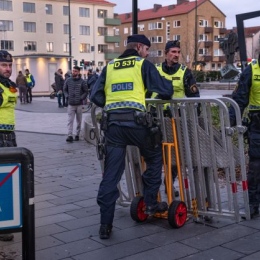 Poliser som bär kravallstaket