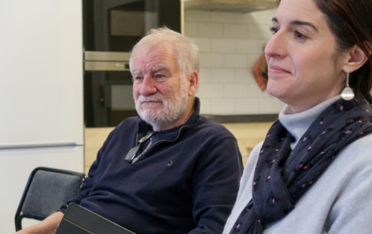 En man och en kvinna sitter bredvid varandra och lyssnar till någon utanför bild.