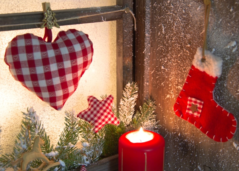 Handmade Christmas window decoration with hart and a red candle.