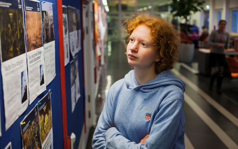 En student tittar på en anslagstavla.
