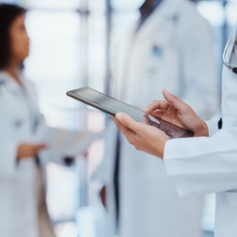 Three medical doctors, one holding an Ipad.