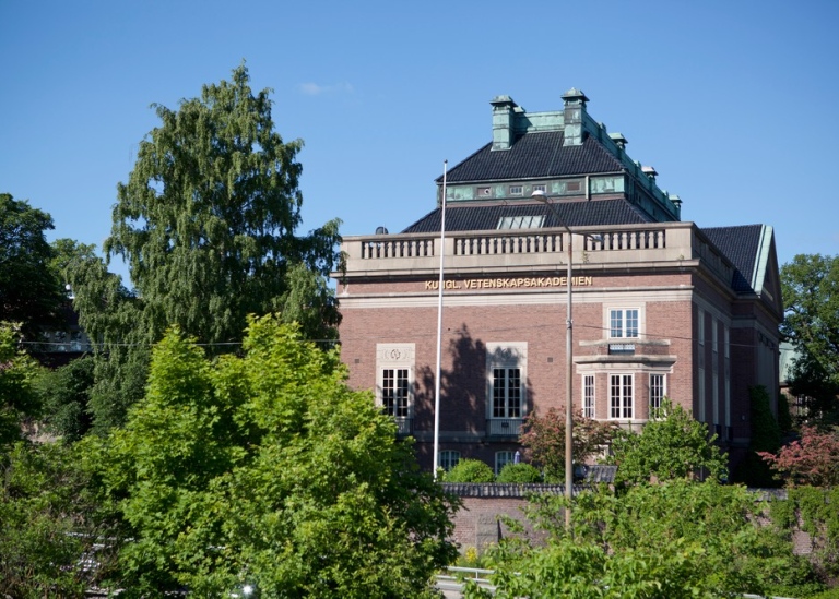 Kungliga Vetenskapsakademien ligger i en tegelbyggnad omgiven av en trädlund