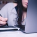 Genrebild distansstudier: En kvinna sitter och jobbar med dator och skrivplatta.