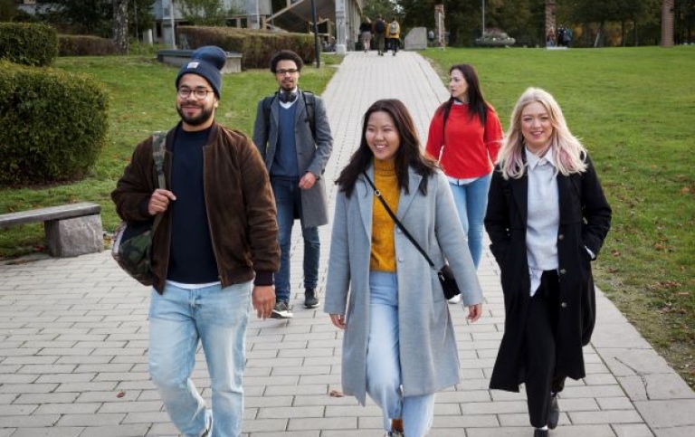 Flera personer som vandrar på campus på promenadstråk.
