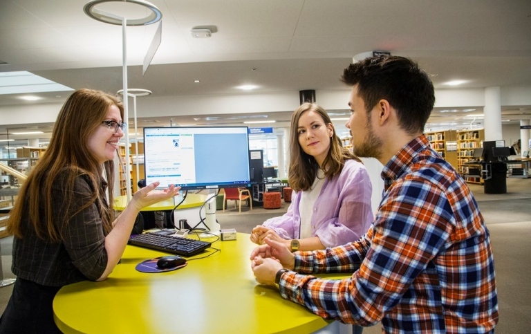 Woman helping twi students in the Stockholm University Library