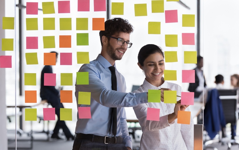 Genre photo of colleagues brainstorming with post-it notes