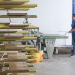 Woman standing beside wooden boards drying after wood gluing at the joinery or carpentry 