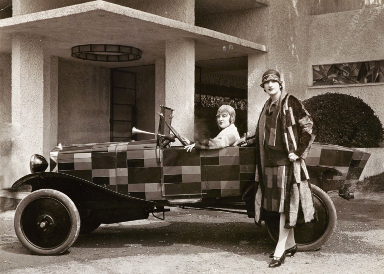 Models wearing Simultanist clothing in front of a Simultanist Citroen designed by Sonia Delaunay, 19