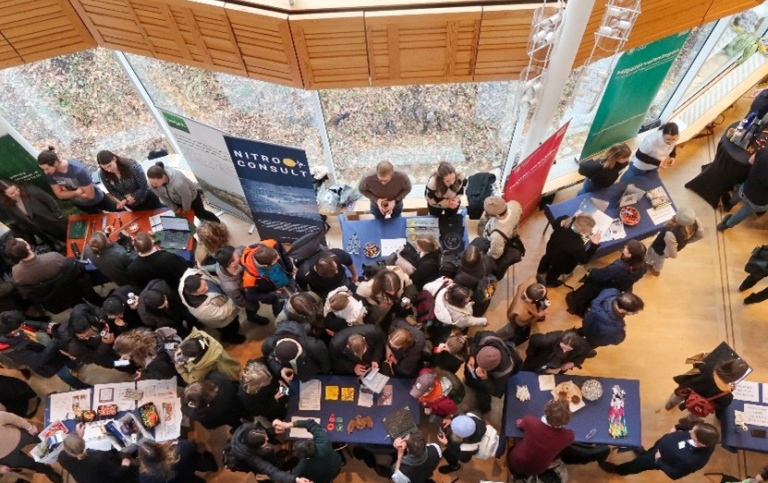 View from above of people at a fair mingling around tables.