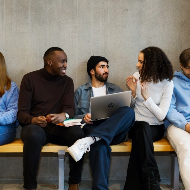 Three students sitting on a bench talking. Photo: Jens Olof Lasthein