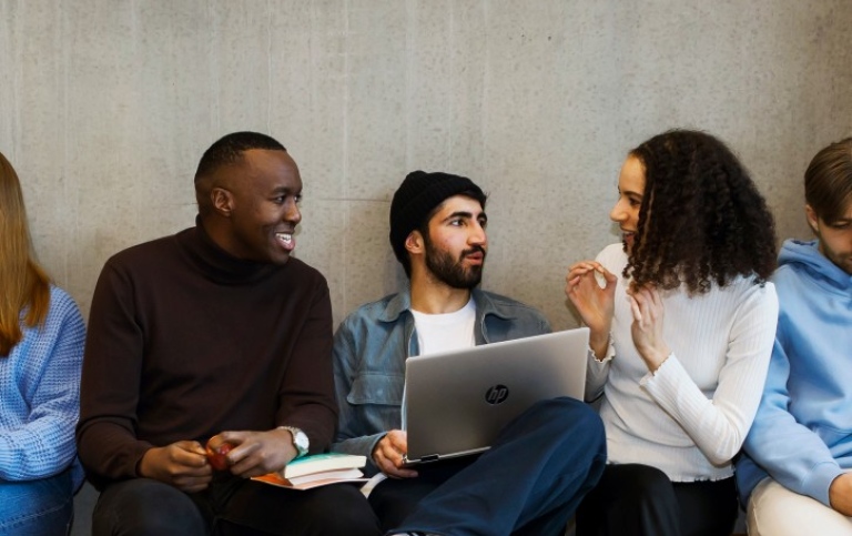 Three students sitting on a bench talking. Photo: Jens Olof Lasthein