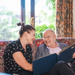 Two people looking in a photo album. A photo from the Age-positive image library.