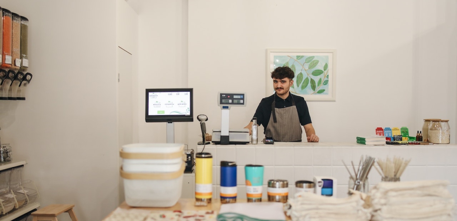A man behind the counter in a small shop. Photo: Polina Tankilevitch from Pexels