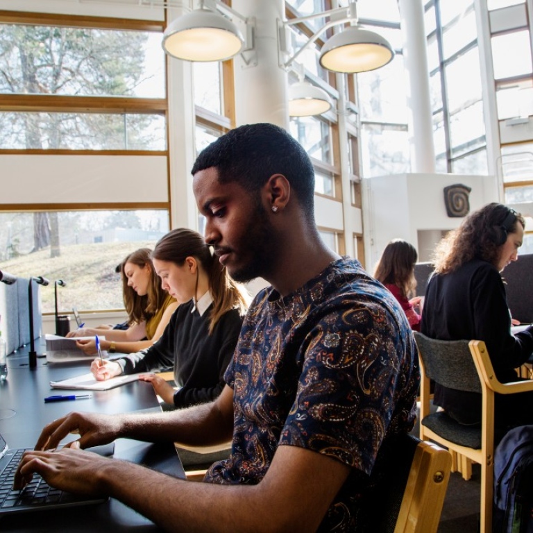 Studenter som pluggar i biblioteket.