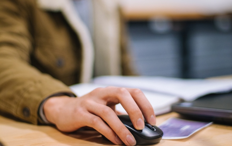 Genre photo of a hand using a computer mouse.