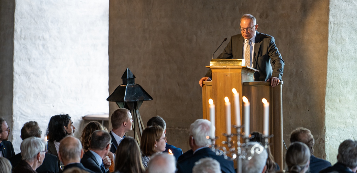 Sverker Lerheden vid talstol, lyssnare sitter i förgrunden.