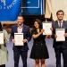 Happy graduates holding diplomas in their hands