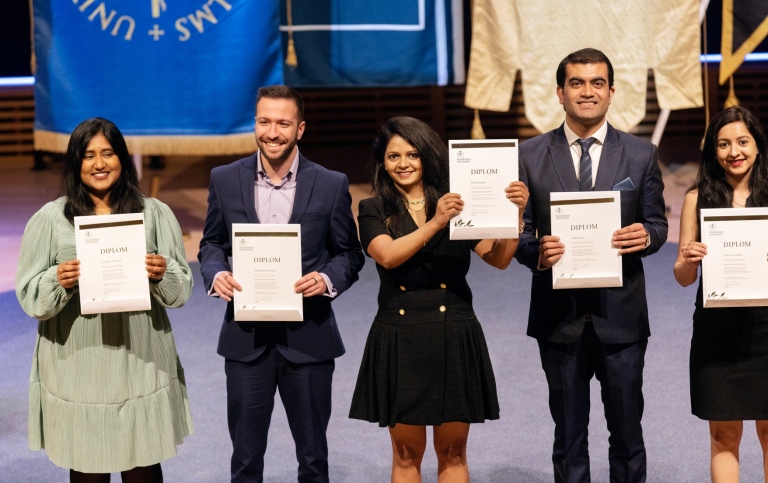 Happy graduates holding diplomas in their hands