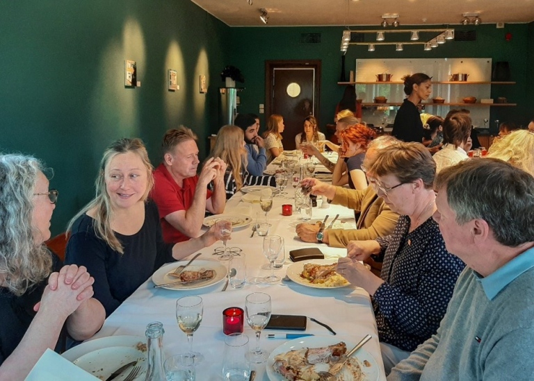 People around a long table for celebratory dinner.