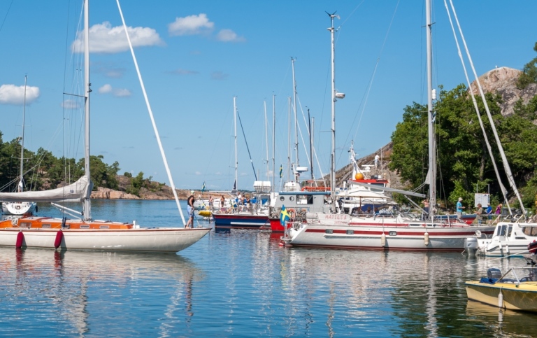 Båtsommar i Sverige - segelbåt angör en brygga på Harstena i Gryts skärgård. Foto Rolf_52/Mostphotos