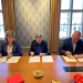 Three persons signing papers.