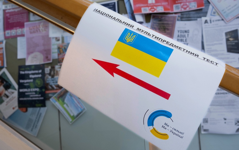 skylt med ukrainsk flagga och röd pil