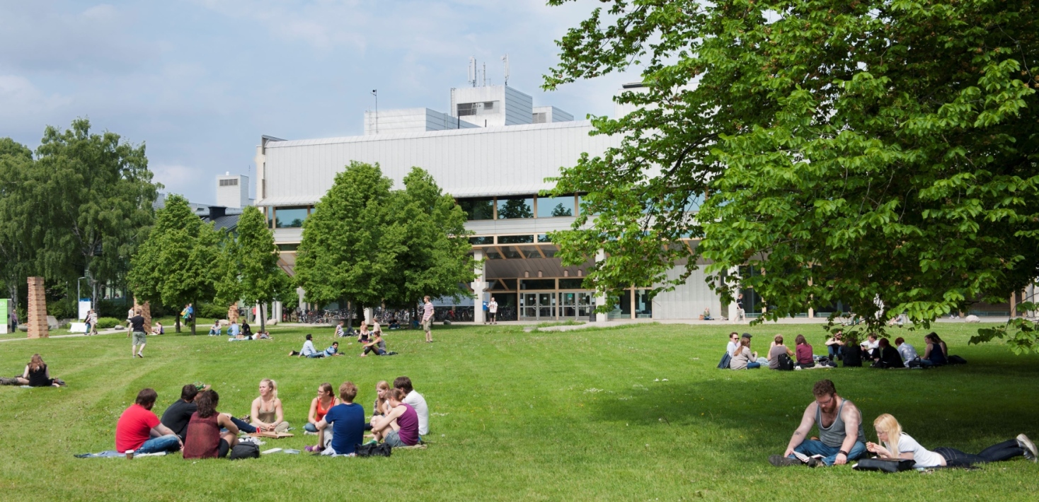 Students sitting outside on the grass outside of the Arrhenius laboratory