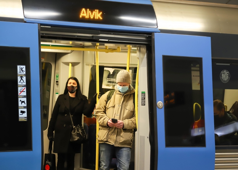 Two commuters wearing face masks in the Stockholm underground.