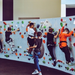 En grupp barn klättrar på en klättervägg