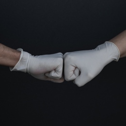 Två händer med handskar som slår nävarna mot varandra