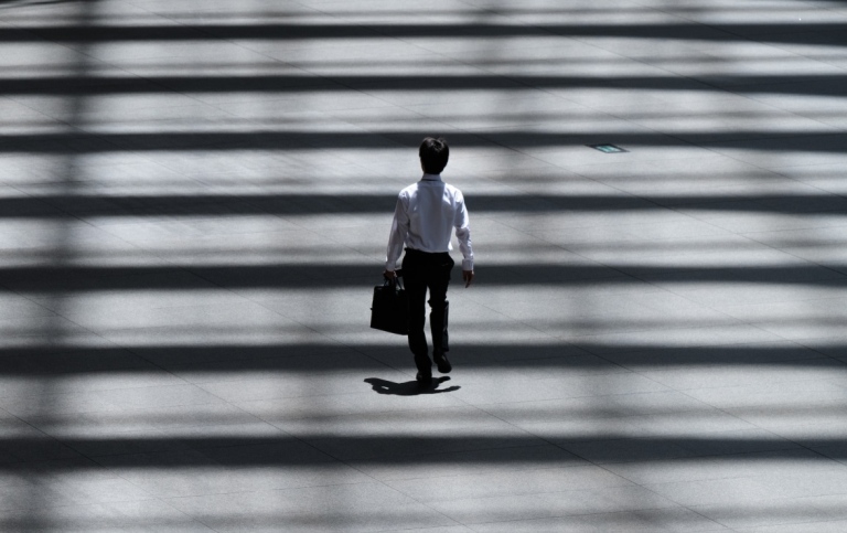 Man with a bag crosses a street