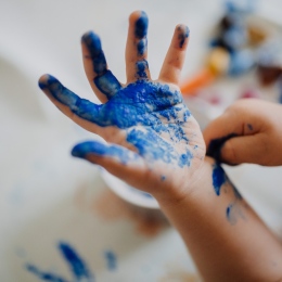 A child's blue-painted hand