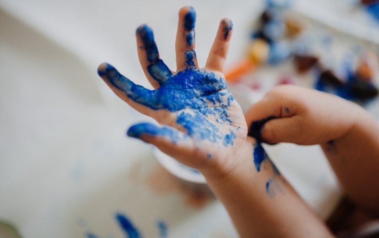 A child's blue-painted hand