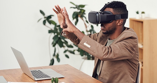 Man vid skrivbord med VR glasögon