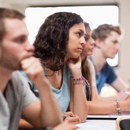 Studenter lyssnar på föreläsning, ung tjej i fokus.