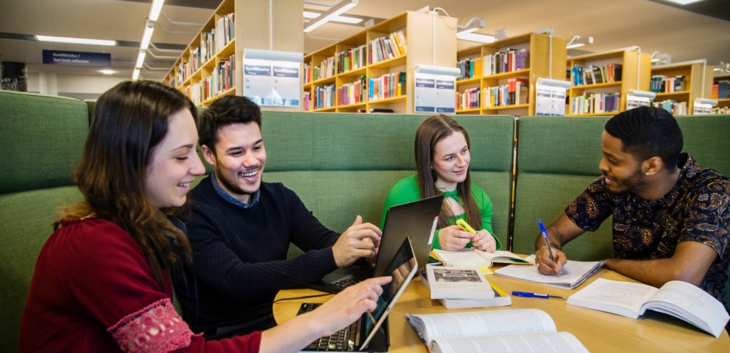 Studenter sitter i grön soffa i Unversitetsbiblioteket. Foto: Lena Katarina Johansson