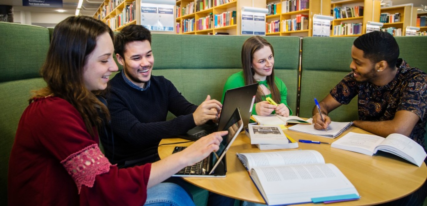 Studenter sitter i grön soffa i Unversitetsbiblioteket. Foto: Lena Katarina Johansson