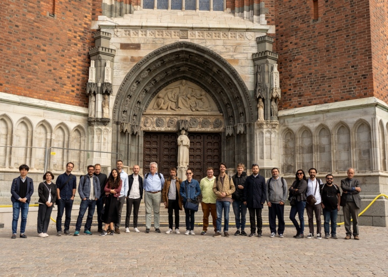 twenty people lined up in front of the entrance to the Cathedral in Uppsala